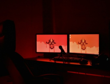 two computer monitors sitting on top of a desk