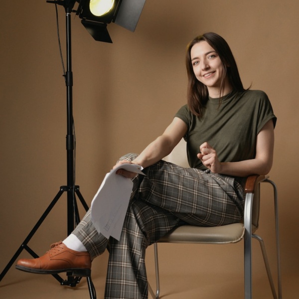 a woman sitting in a chair in front of a light